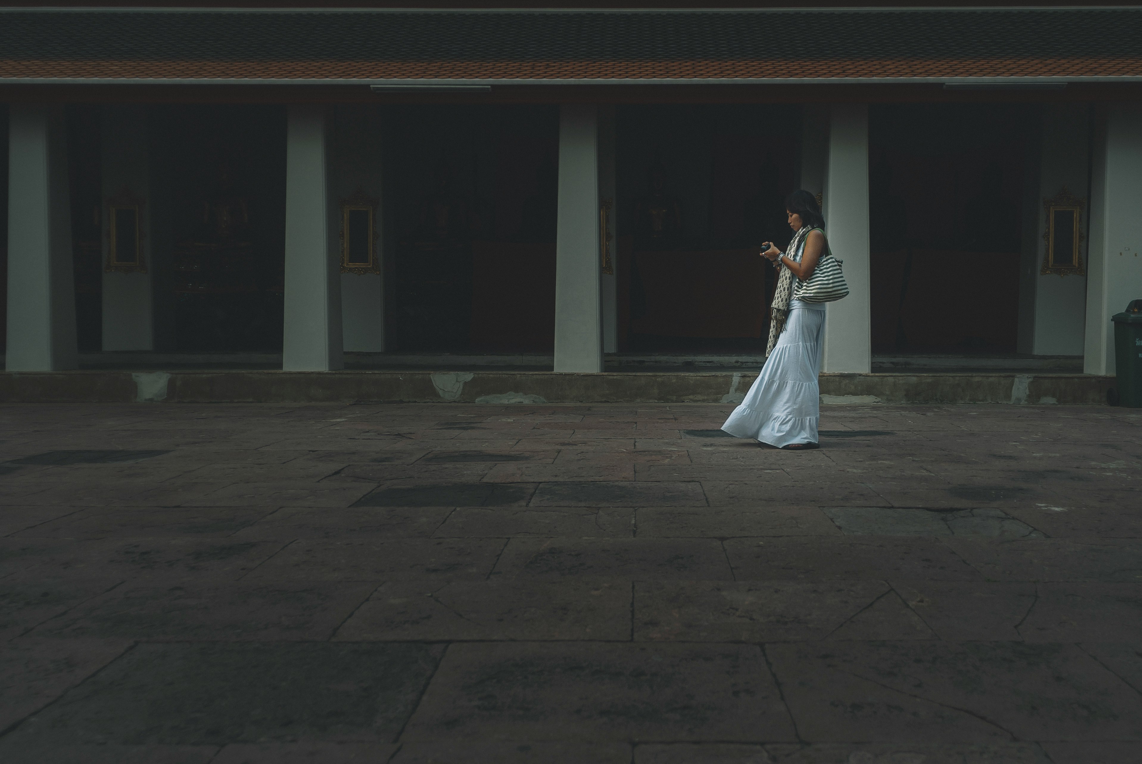 woman in white dress walking on gray concrete floor